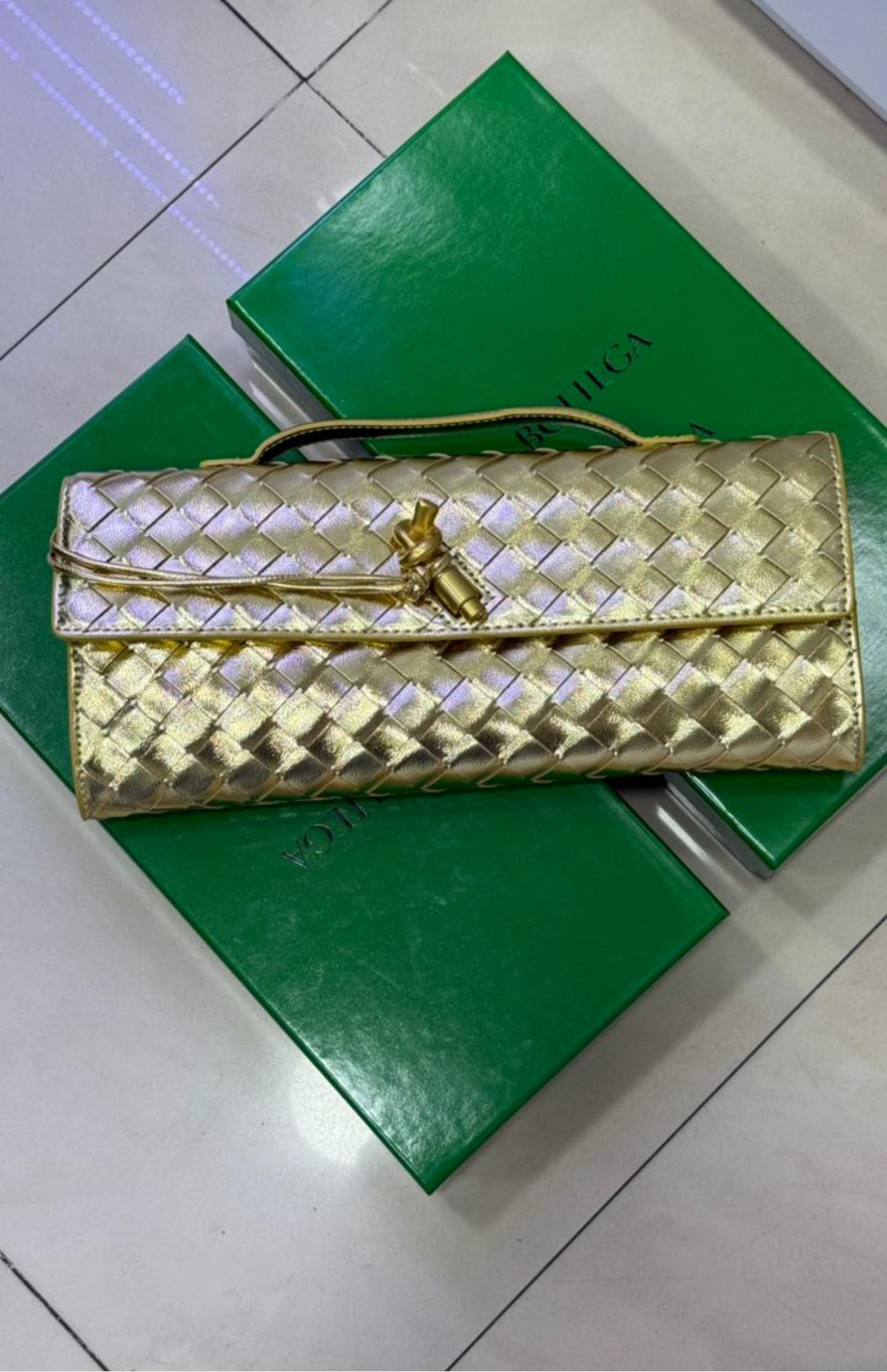 Pochette à Intrecciato effet miroir avec fermeture knot signature.