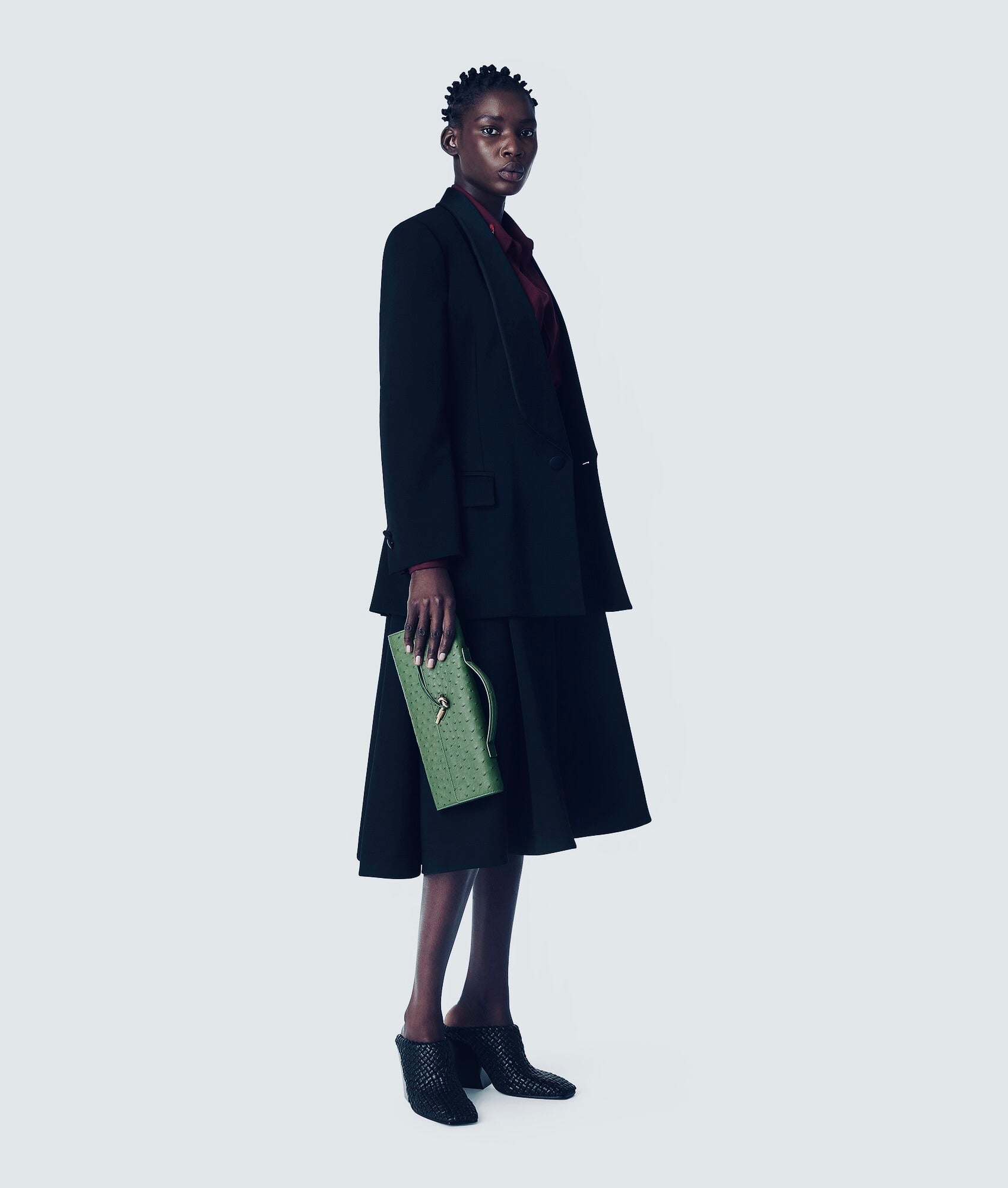 Pochette à anse en autruche avec fermeture knot signature.